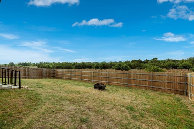 view of yard with a fire pit and a fenced backyard