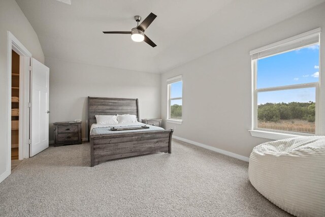 carpeted bedroom featuring vaulted ceiling, baseboards, and ceiling fan