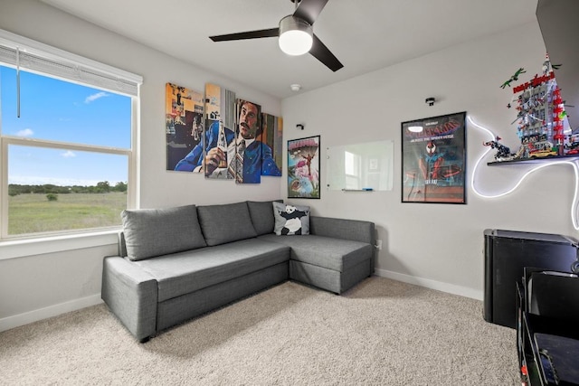 carpeted living room featuring ceiling fan, baseboards, and a healthy amount of sunlight