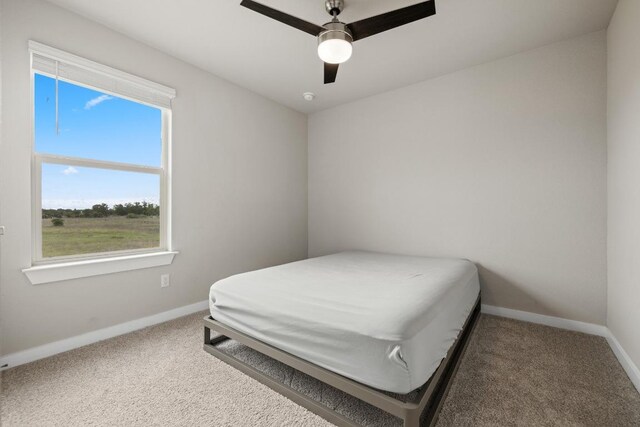bedroom with ceiling fan, carpet floors, and baseboards