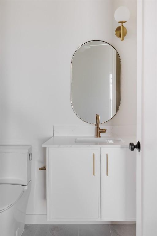 half bath featuring vanity and toilet