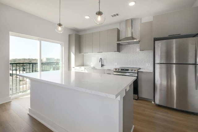 2500 Longview St Unit 501, Austin, TX 78705 - kitchen featuring appliances with stainless steel finishes, wall chimney range hood, wood finished floors, decorative backsplash, and recessed lighting