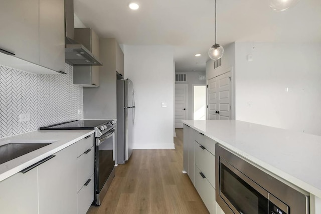 2500 Longview St Unit 501, Austin, TX 78705 - kitchen featuring stainless steel appliances, modern cabinets, wall chimney range hood, light countertops, and tasteful backsplash