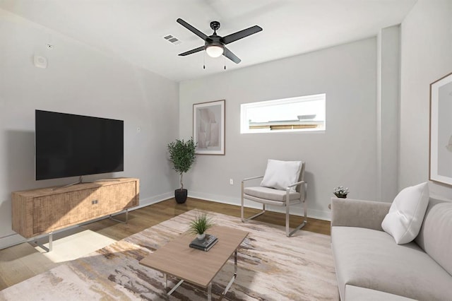 living room featuring visible vents, baseboards, wood finished floors, and ceiling fan