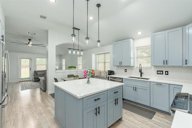 129 Aguilar Dr, Hutto, TX 78634 - kitchen with ceiling fan, healthy amount of natural light, a kitchen island, light wood finished floors, and recessed lighting