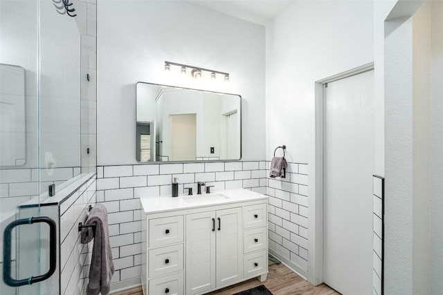 129 Aguilar Dr, Hutto, TX 78634 - bathroom with tile walls, vanity, a shower stall, and wood finished floors