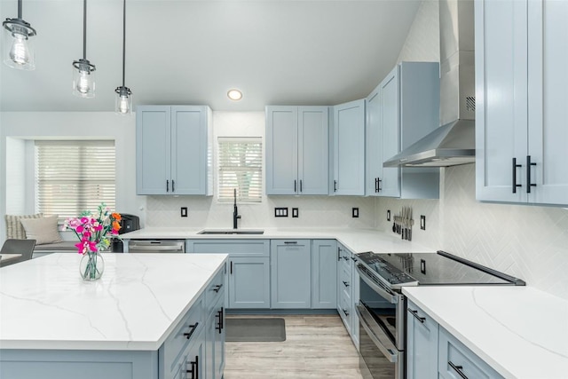 129 Aguilar Dr, Hutto, TX 78634 - kitchen with wall chimney range hood, appliances with stainless steel finishes, light stone countertops, tasteful backsplash, and recessed lighting