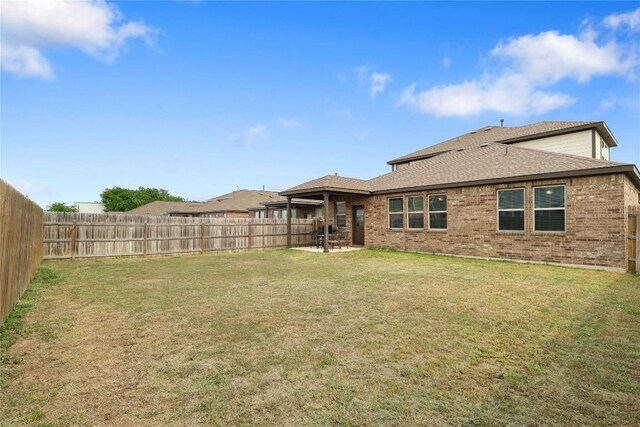 345 Coba St, Leander, TX 78641 - rear view of property with a fenced backyard, brick siding, a shingled roof, and a patio area
