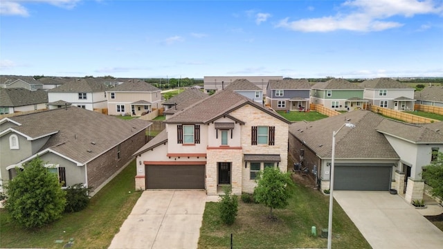 345 Coba St, Leander, TX 78641 - view of front of house featuring stone siding, a residential view, driveway, stucco siding, and a garage