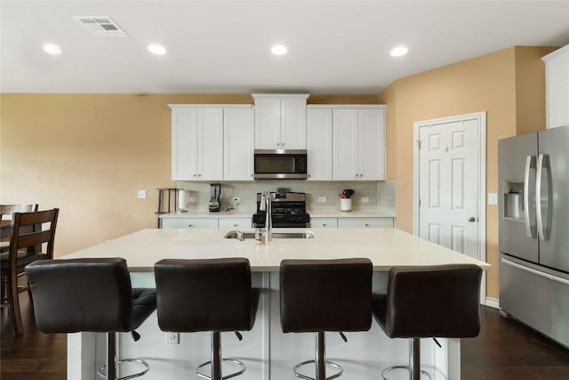 345 Coba St, Leander, TX 78641 - kitchen featuring appliances with stainless steel finishes, tasteful backsplash, dark wood-type flooring, light countertops, and recessed lighting