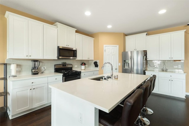 345 Coba St, Leander, TX 78641 - kitchen featuring stainless steel appliances, a sink, backsplash, a breakfast bar, and dark wood finished floors