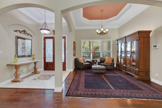 1164 Fairway Dr, Canyon Lake, TX 78133 - entrance foyer with wood finished floors, arched walkways, an inviting chandelier, a tray ceiling, and baseboards