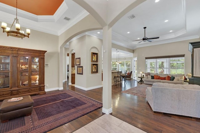 1164 Fairway Dr, Canyon Lake, TX 78133 - living room featuring a tray ceiling, visible vents, arched walkways, wood finished floors, and ceiling fan with notable chandelier