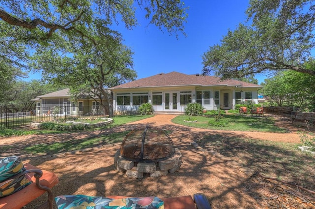 1164 Fairway Dr, Canyon Lake, TX 78133 - rear view of property featuring fence, french doors, a lawn, an outdoor fire pit, and a sunroom