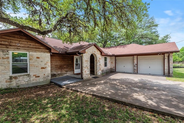 104 Tonkawa Cv, Kyle, TX 78640 - ranch-style house featuring an attached garage, driveway, and stone siding