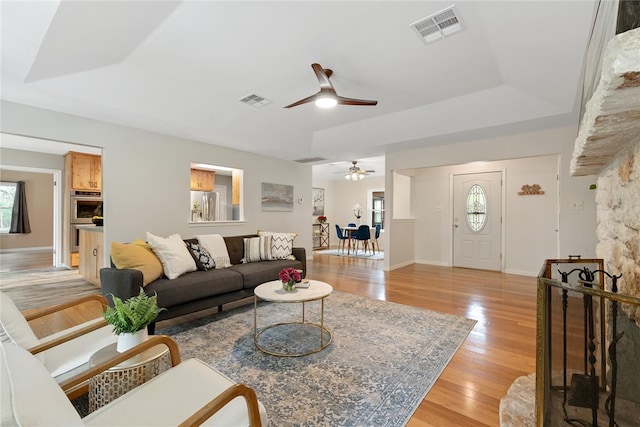 104 Tonkawa Cv, Kyle, TX 78640 - living area with a tray ceiling, visible vents, light wood finished floors, and ceiling fan