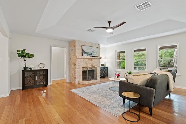 104 Tonkawa Cv, Kyle, TX 78640 - living room featuring a raised ceiling, light wood-style floors, visible vents, and ceiling fan