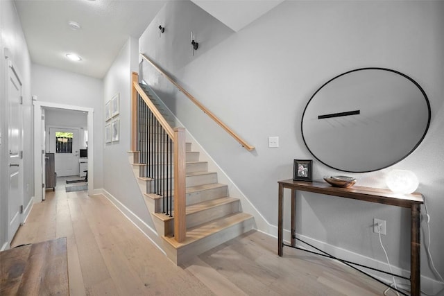 stairway featuring recessed lighting, wood finished floors, and baseboards
