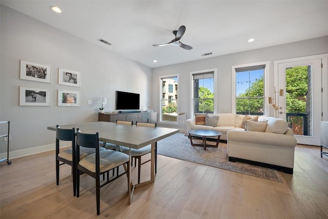 living area featuring a wealth of natural light, light wood-style flooring, visible vents, and baseboards