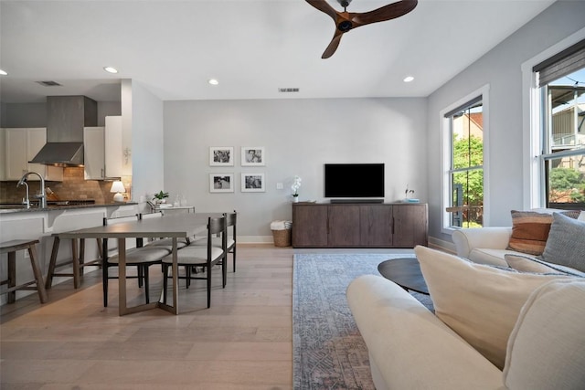 living area featuring recessed lighting, visible vents, light wood-style floors, baseboards, and ceiling fan