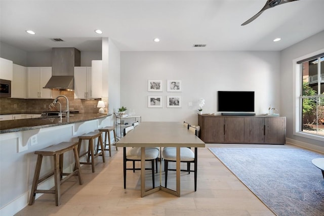 dining space with light wood finished floors, a ceiling fan, visible vents, and recessed lighting