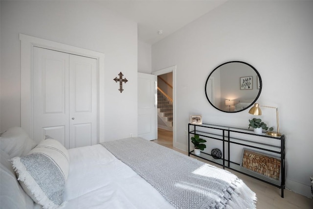 bedroom featuring wood finished floors, a closet, and baseboards
