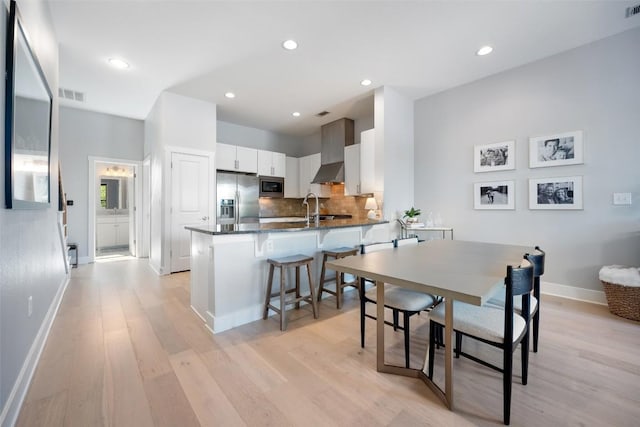dining room featuring baseboards, visible vents, recessed lighting, and light wood-style floors
