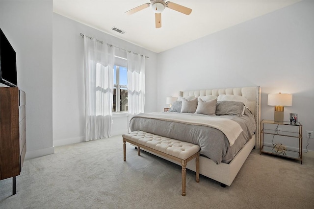 carpeted bedroom with baseboards, a ceiling fan, and visible vents