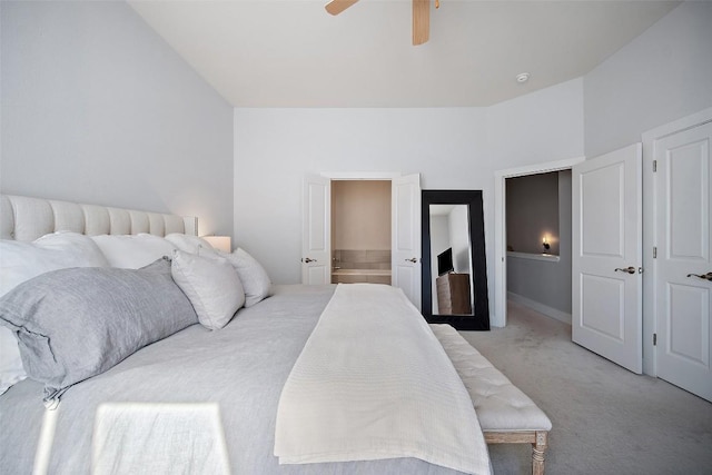 bedroom featuring light carpet, a ceiling fan, and ensuite bathroom