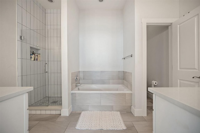 full bathroom featuring a garden tub, tile patterned flooring, a stall shower, and vanity