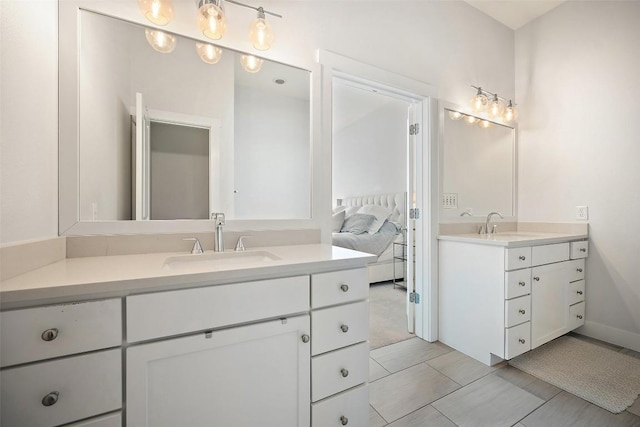 ensuite bathroom with two vanities, connected bathroom, and a sink