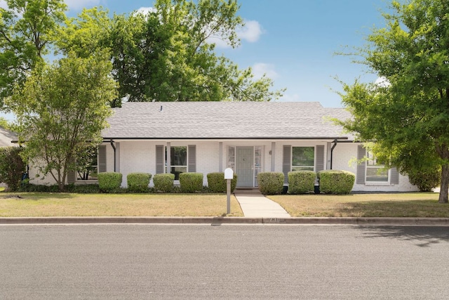ranch-style house featuring brick siding and a front lawn