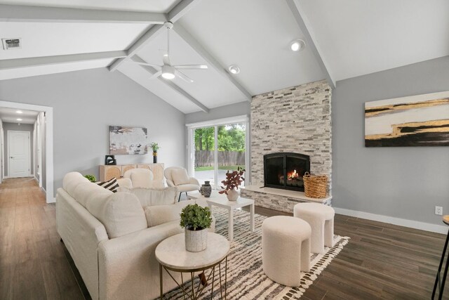 living area with wood finished floors, visible vents, vaulted ceiling with beams, a fireplace, and ceiling fan