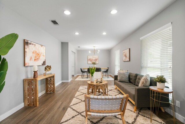 living area with baseboards, wood finished floors, visible vents, and recessed lighting