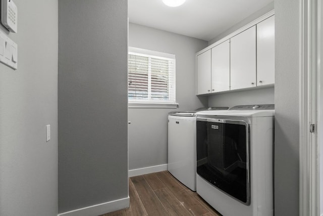 laundry room with cabinet space, independent washer and dryer, baseboards, and dark wood-style flooring