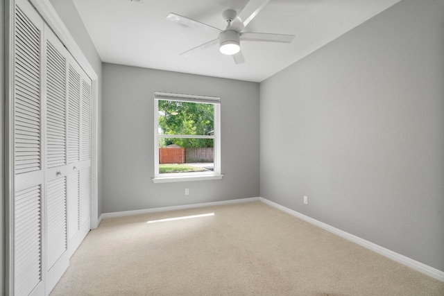 unfurnished bedroom featuring light carpet, baseboards, and a closet