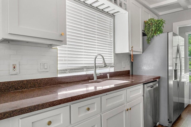 3212 Darnell Dr, Austin, TX 78745 - kitchen featuring stainless steel dishwasher, white cabinetry, backsplash, wood finished floors, and beamed ceiling
