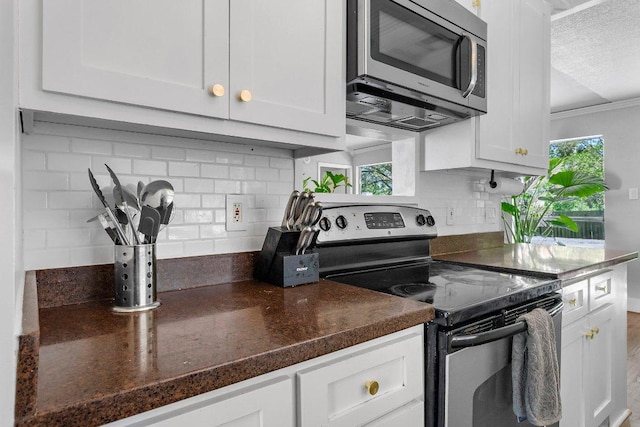 3212 Darnell Dr, Austin, TX 78745 - kitchen featuring stainless steel appliances, white cabinets, tasteful backsplash, a textured ceiling, and crown molding