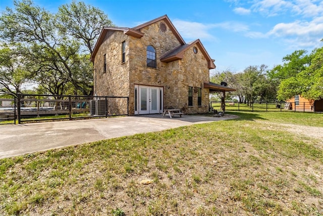 7557 Chaparral Rd, Killeen, TX 76542 - rear view of property featuring a patio area, a lawn, stone siding, french doors, and fence