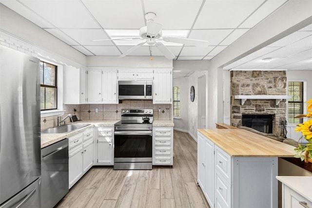 7557 Chaparral Rd, Killeen, TX 76542 - kitchen featuring a sink, butcher block countertops, a drop ceiling, ceiling fan, and appliances with stainless steel finishes
