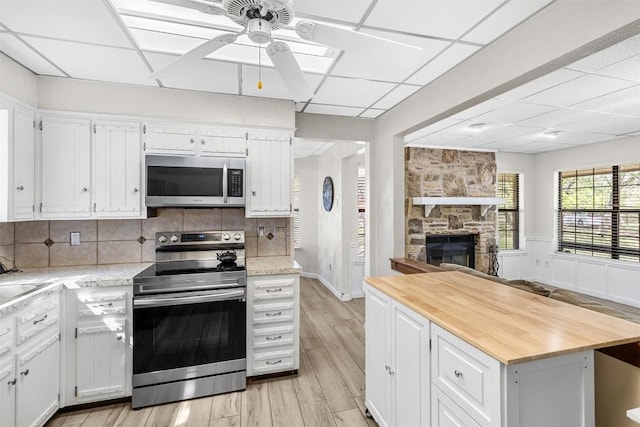 7557 Chaparral Rd, Killeen, TX 76542 - kitchen with white cabinetry, a ceiling fan, stainless steel appliances, and butcher block countertops