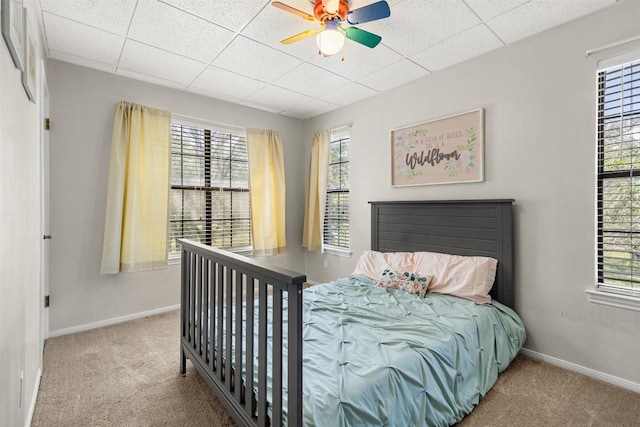 7557 Chaparral Rd, Killeen, TX 76542 - carpeted bedroom with multiple windows, baseboards, ceiling fan, and a drop ceiling