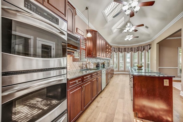 36 Cottondale Rd, The Hills, TX 78738 - kitchen featuring stainless steel appliances, a kitchen island, ceiling fan, ornamental molding, and light wood finished floors