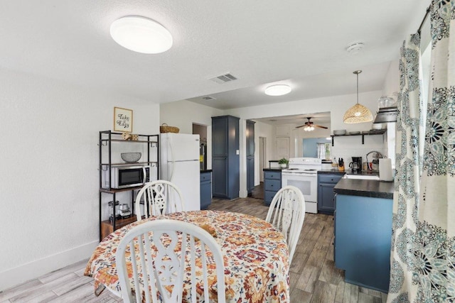 dining space with wood finished floors, visible vents, baseboards, and ceiling fan