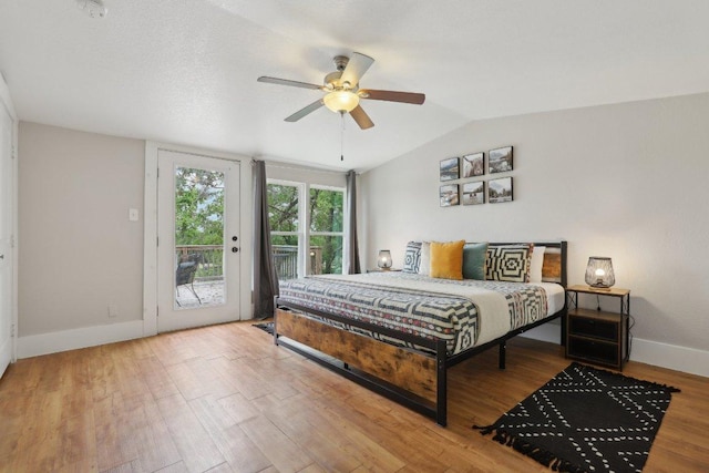 bedroom featuring access to exterior, baseboards, lofted ceiling, a ceiling fan, and wood finished floors