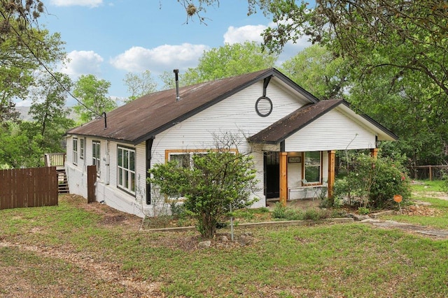 bungalow-style home with stairs, a front lawn, and fence