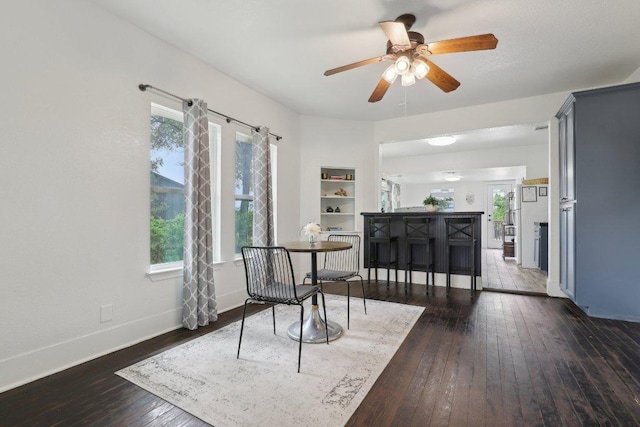 living area with ceiling fan, baseboards, and wood-type flooring