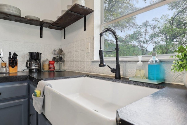 interior details with backsplash, dark countertops, open shelves, and a sink