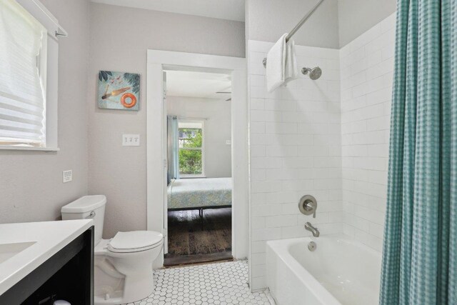 ensuite bathroom with ensuite bath, toilet, vanity, and shower / tub combo with curtain