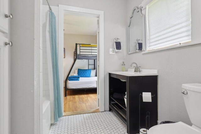 bathroom with tile patterned floors, toilet, vanity, and shower / bathtub combination with curtain